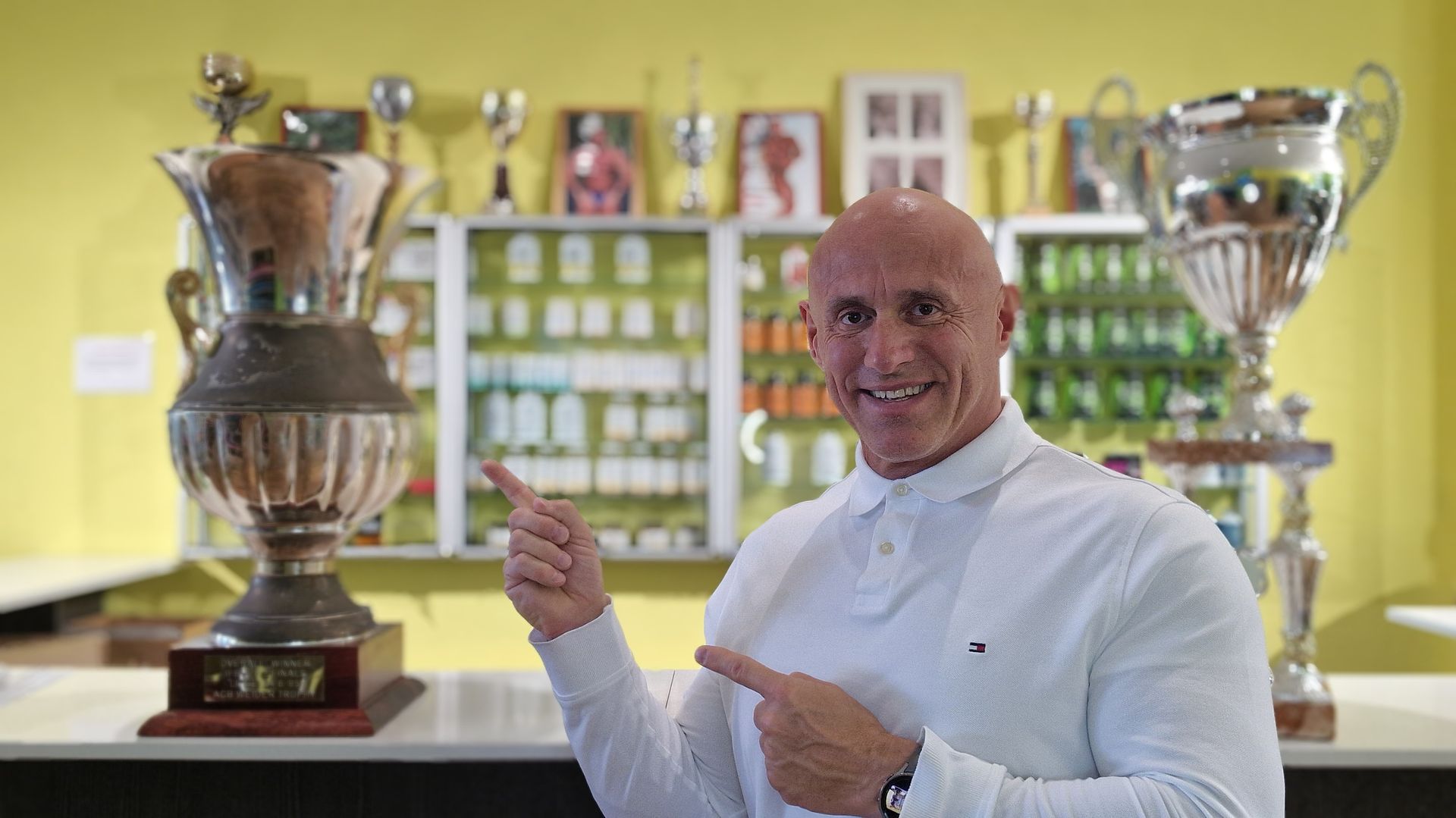 Eric Carpentier qui pose à coté d'un trophé dans son magasin SF&NUTRITION